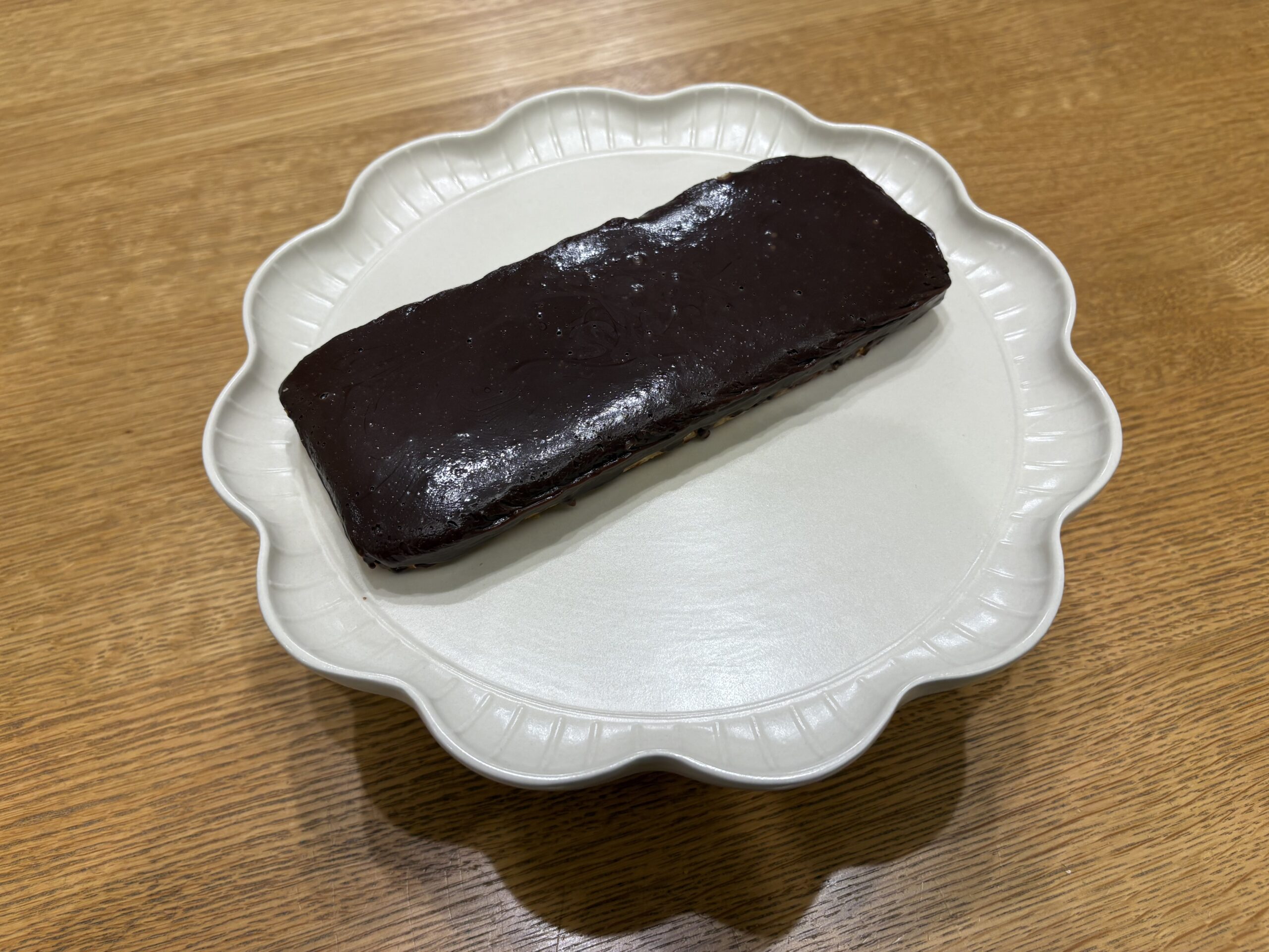 白いお皿にのせた、つやのある生チョコタルト