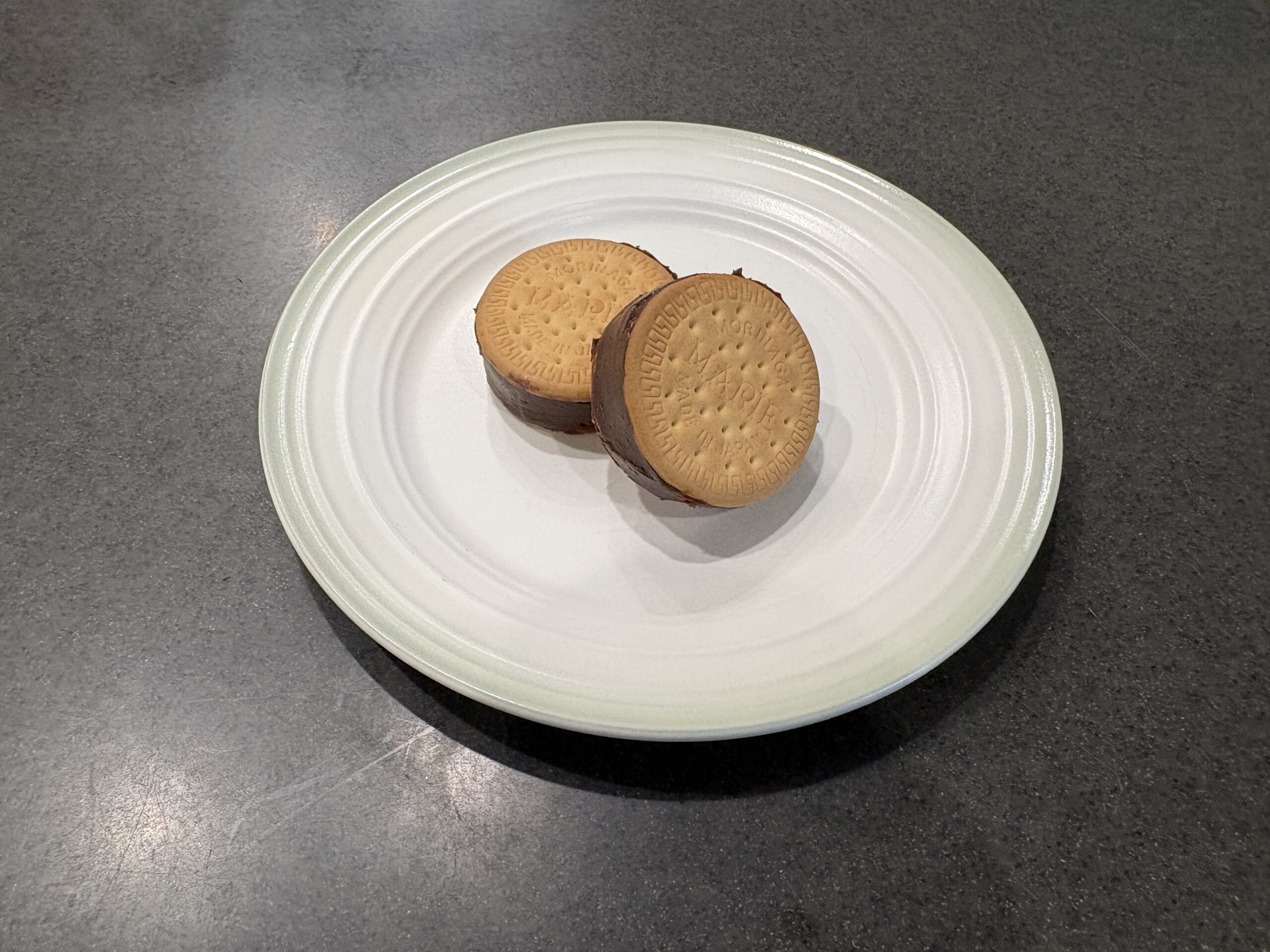 白い皿に盛られた手作りの生チョコサンドクッキー2個
